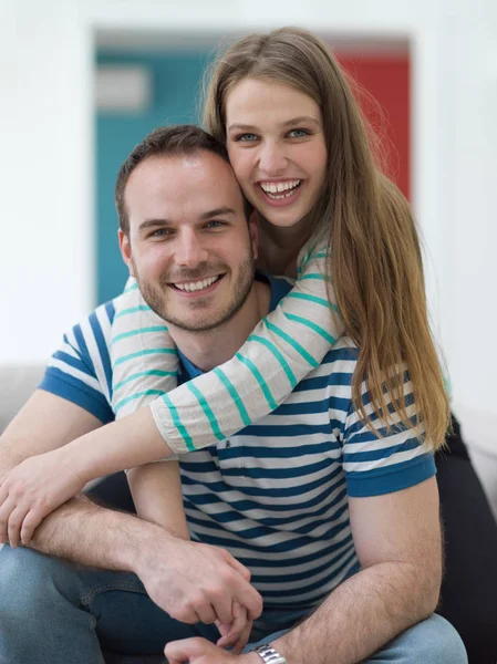 Giovane bella coppia che si abbraccia sul divano — Foto Stock