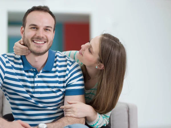 Jovem casal bonito abraçando no sofá — Fotografia de Stock