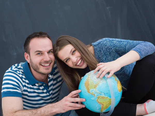 Paar in casual kleding onderzoeken van globe — Stockfoto