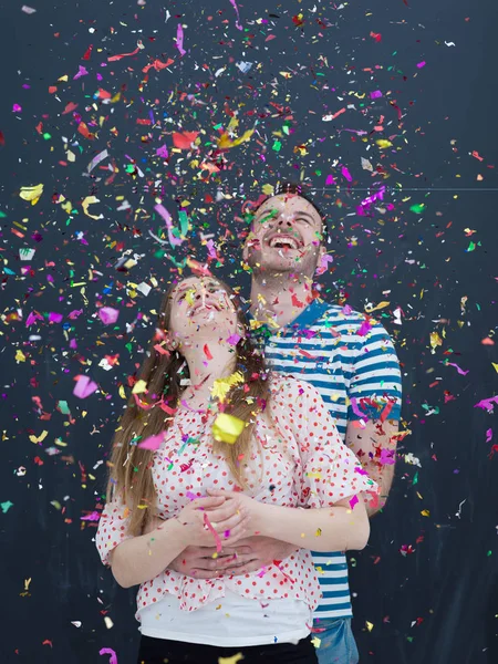 Paar waait confetti in de lucht geïsoleerd over grijs — Stockfoto