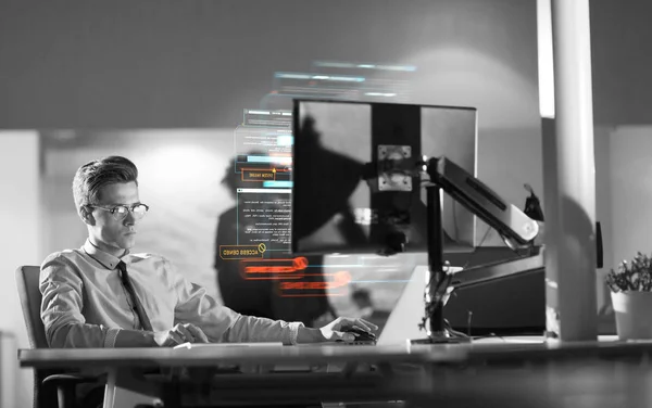 Mann arbeitet im dunklen Büro am Computer — Stockfoto