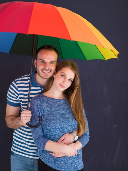 Knappe paar met een kleurrijke paraplu — Stockfoto