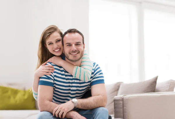 Junges hübsches Paar, das sich auf dem Sofa umarmt — Stockfoto