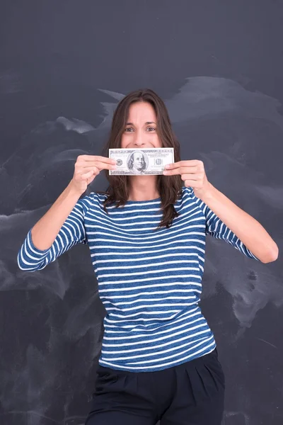 Woman holding a banknote in front of chalk drawing board — Stock Photo, Image