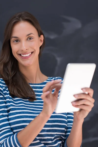 Mulher usando tablet na frente da placa de desenho de giz — Fotografia de Stock