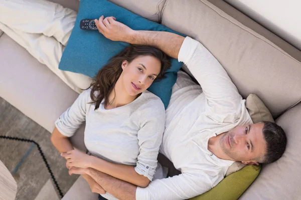 Jovem casal no sofá assistindo televisão vista superior — Fotografia de Stock