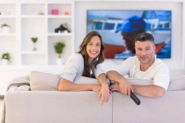 Jovem casal no sofá assistindo televisão — Fotografia de Stock