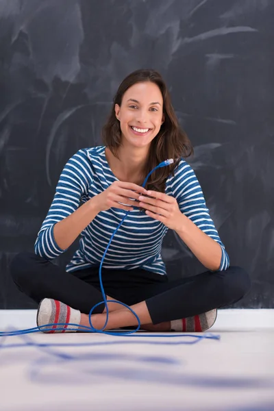 Kvinna som håller en internet kabel framför krita ritbordet — Stockfoto