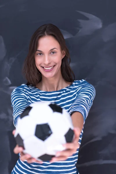 Femme tenant un ballon de football devant la planche à dessin à la craie — Photo