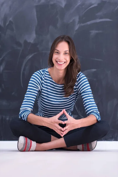 Woman sitting in front of chalk drawing board — Stock Photo, Image