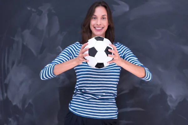 Femme tenant un ballon de football devant la planche à dessin à la craie — Photo