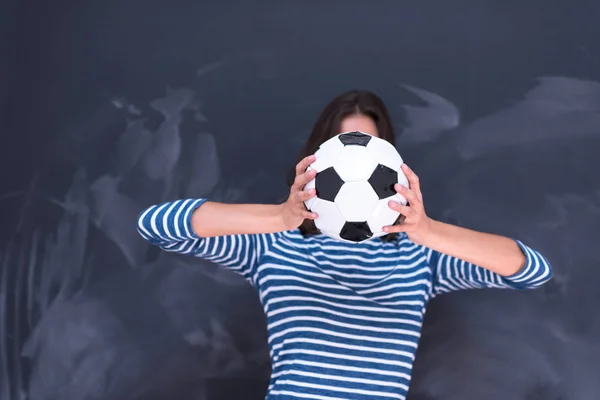 Donna che tiene un pallone da calcio davanti al tavolo da disegno in gesso — Foto Stock