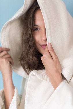 Beyaz önlük üzerinde mavi arka plan izole kukuleta ile kadında