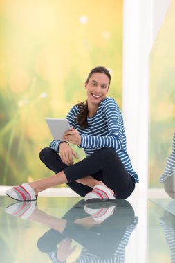 Tablet bilgisayar kullanan genç bir kadın 