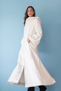 Beyaz önlük üzerinde mavi arka plan izole kukuleta ile kadında