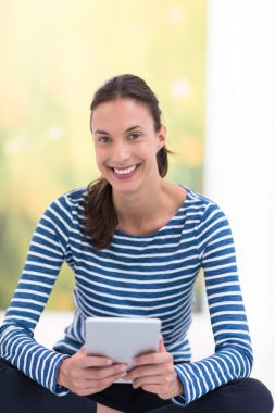 Tablet bilgisayar kullanan genç bir kadın 