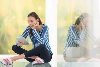 Tablet bilgisayar kullanan genç bir kadın 