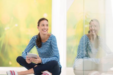 Tablet bilgisayar kullanan genç bir kadın 