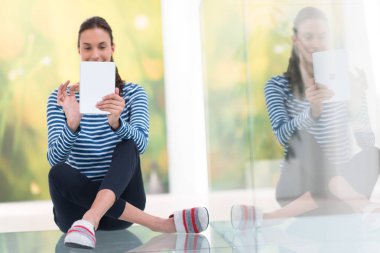 Tablet bilgisayar kullanan genç bir kadın 