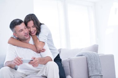 Evde cep telefonu kullanan mutlu çift.