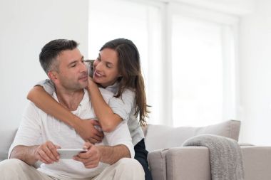 Evde cep telefonu kullanan mutlu çift.