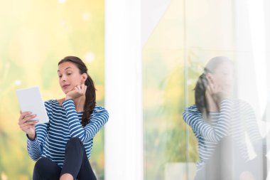 Tablet bilgisayar kullanan genç bir kadın 