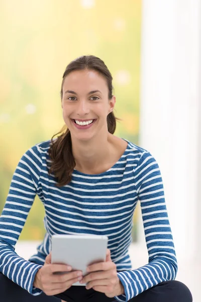 Tablet bilgisayar kullanan genç bir kadın 