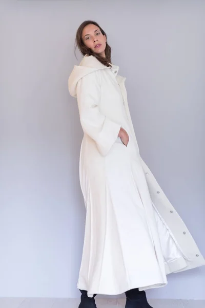 Γυναίκα σε ένα άσπρο παλτό με κουκούλα που απομονώνονται σε λευκό φόντο — Φωτογραφία Αρχείου