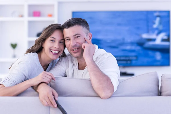 Giovane coppia sul divano a guardare la televisione — Foto Stock