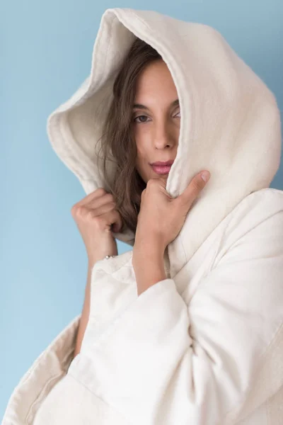 Wanita dalam mantel putih dengan kap terisolasi pada latar belakang biru — Stok Foto