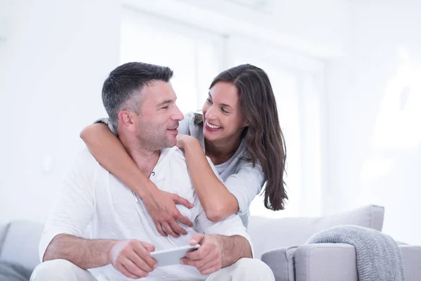 Casal feliz usando telefone celular em casa — Fotografia de Stock