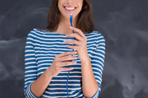 Mujer sosteniendo un cable de Internet delante de la pizarra de dibujo — Foto de Stock