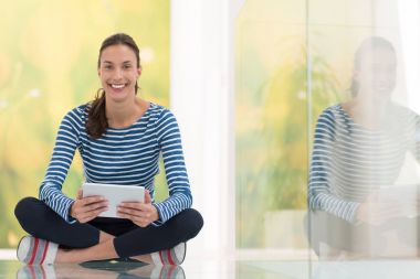 Tablet bilgisayar kullanan genç bir kadın 