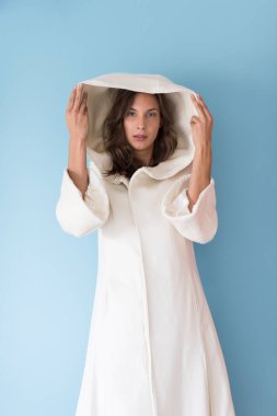 Beyaz önlük üzerinde mavi arka plan izole kukuleta ile kadında