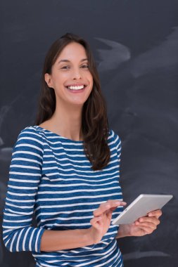 Tebeşir çizim kurulu önünde tablet kullanan kadın