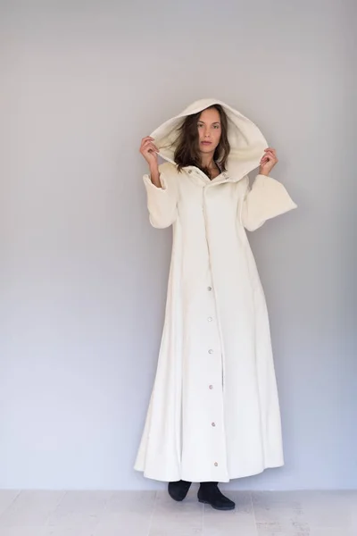 Жінка в білому пальто з капюшоном ізольована на білому тлі — стокове фото