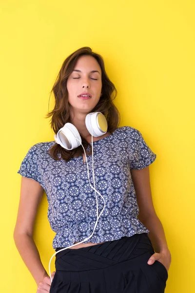 Mujer con auriculares aislados en un amarillo — Foto de Stock