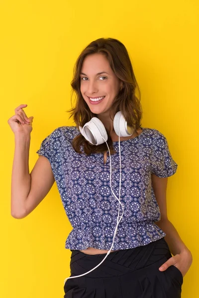 Kvinna med hörlurar isolerad på en gul — Stockfoto