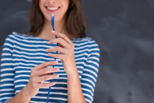 Kvinna som håller en internet kabel framför krita ritbordet — Stockfoto