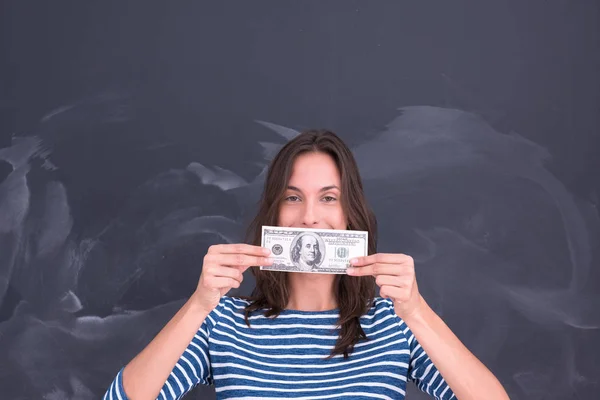 Frau hält Geldschein vor Kreidezeichenbrett — Stockfoto