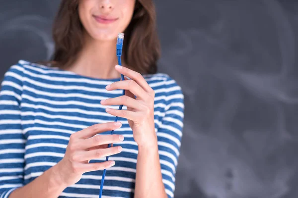 Woman holding a internet cable in front of chalk drawing board — Stock Photo, Image