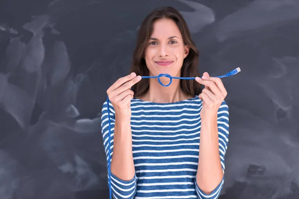 Mujer sosteniendo un cable de Internet delante de la pizarra de dibujo —  Fotos de Stock