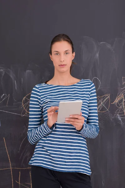 Woman using tablet  in front of chalk drawing board — Stock Photo, Image