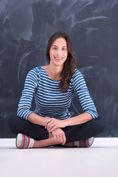 Mujer sentada frente al tablero de dibujo de tiza — Foto de Stock