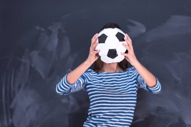 bir futbol topu tebeşir çizim kurulu önünde tutan kadın