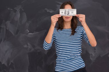 bir banknot tebeşir çizim kurulu önünde tutan kadın