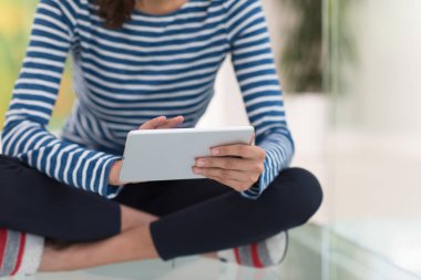 tablet bilgisayar yere kullanan genç kadın