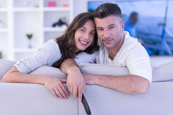 Jovem casal no sofá assistindo televisão — Fotografia de Stock