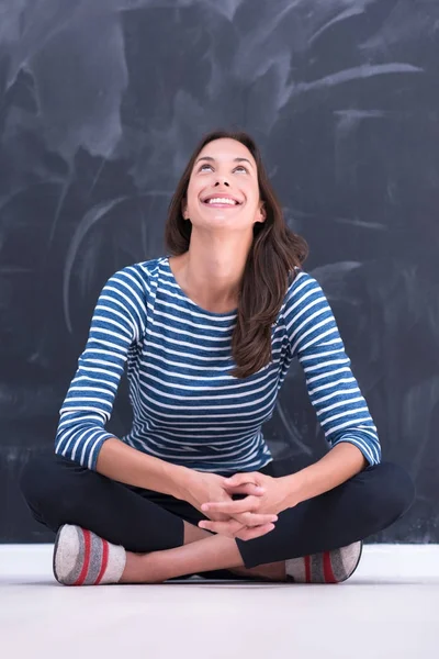 Woman sitting in front of chalk drawing board — Stock Photo, Image