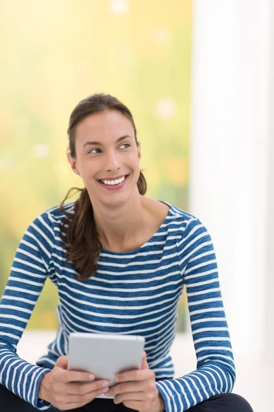 Jonge vrouw met behulp van tablet pc op de verdieping — Stockfoto